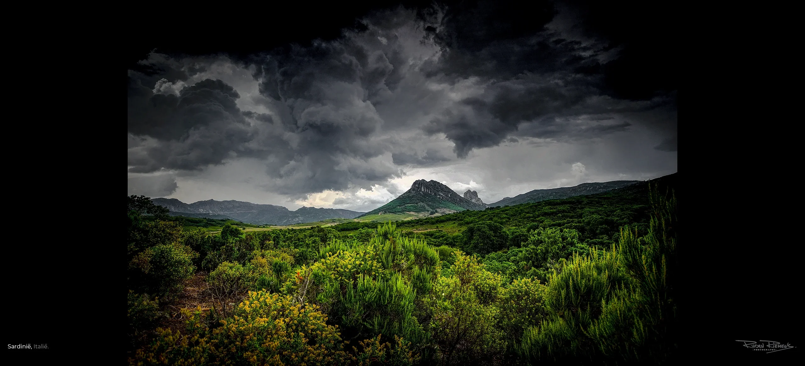 Landschapsfoto uit Sardinië van bergtop en groen onder dreigende lucht, mooi voor aan de wand, Ruden Riemens Photography Onderweg.