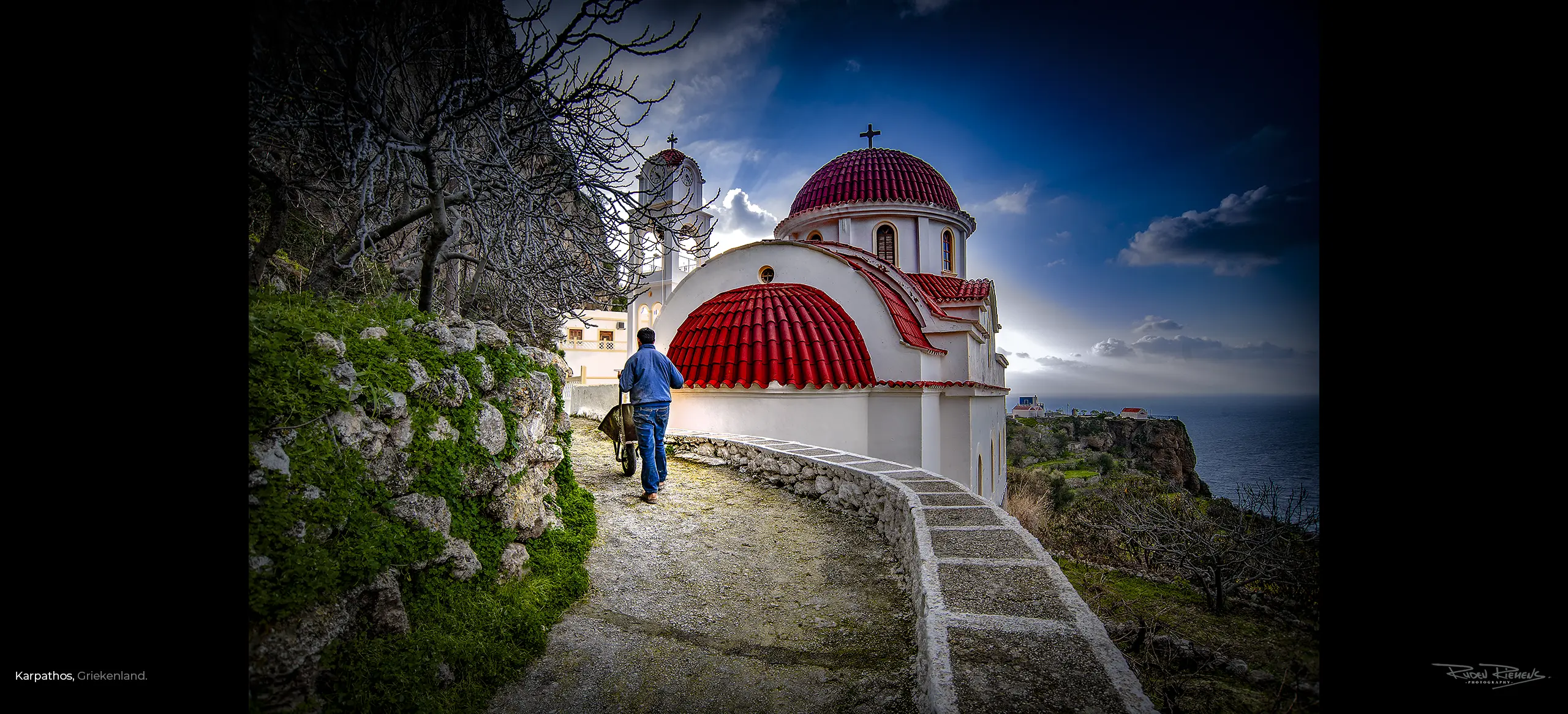 Kerkje met man met kruiwagen aan de kust bij Karpathos Griekenland, Ruden Riemens Photography.