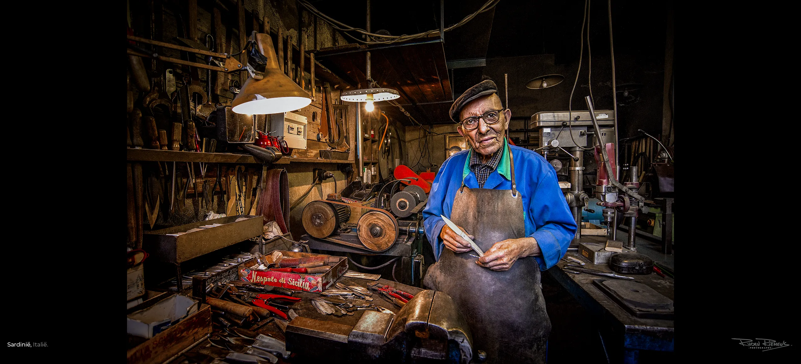 Portret van een 90-jarige messenmaker in zijn werkplaats in Gavoi Sardinië, een bluezone in Italië, gemaakt door Ruden Riemens Photography Onderweg.