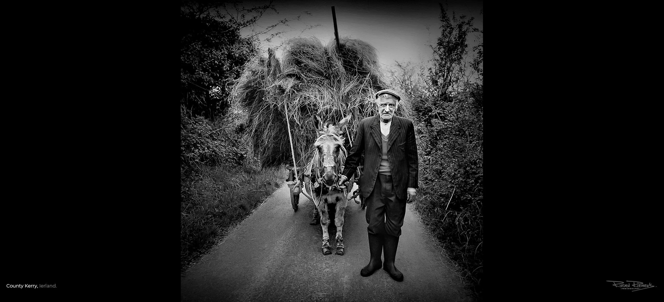 Portret van een oude boer met ezel en hooiwagen op een verlaten weggetje, foto van Ruden Riemens Photography Onderweg.