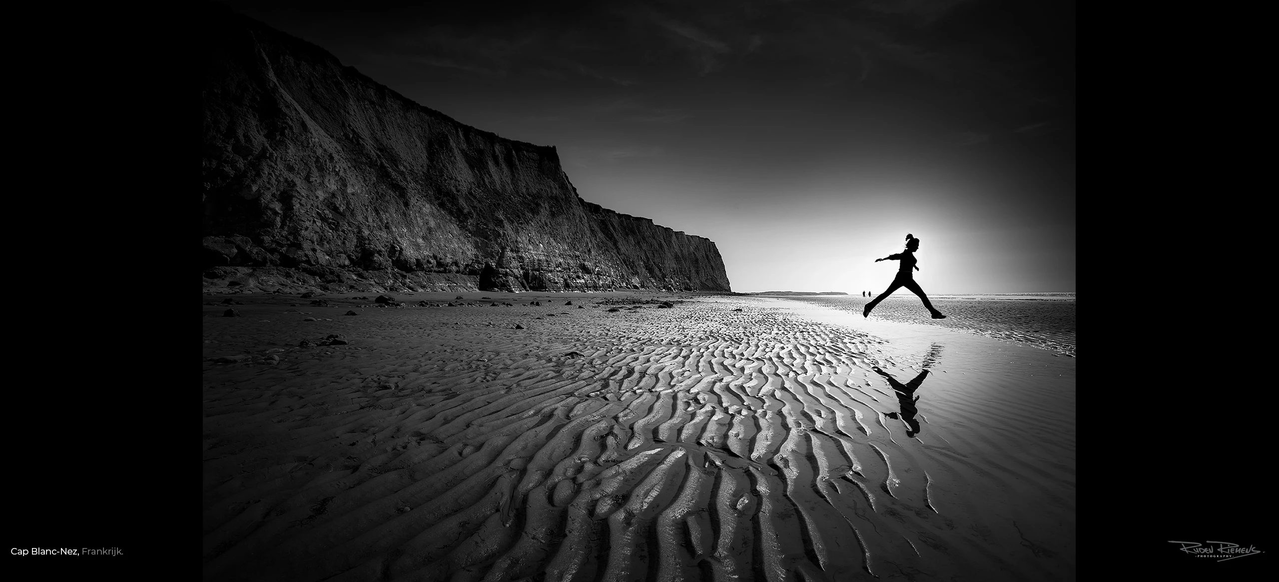 Vrouw springt over water op strand Cap Blanc-Nez Frankrijk, Ruden Riemens Photography Onderweg.