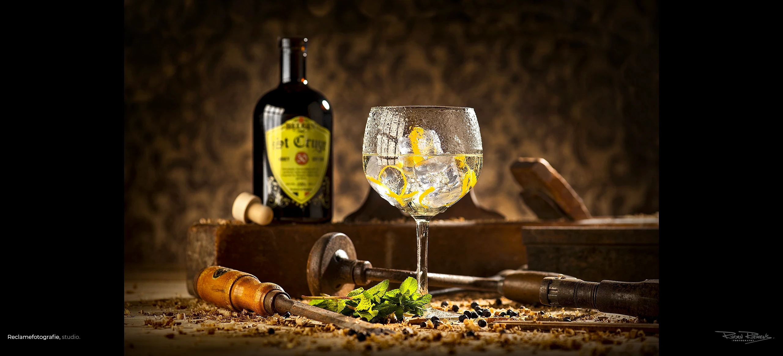 Stilleven van glas gin met oud gereedschap voor website, gemaakt door Ruden Riemens Photography.