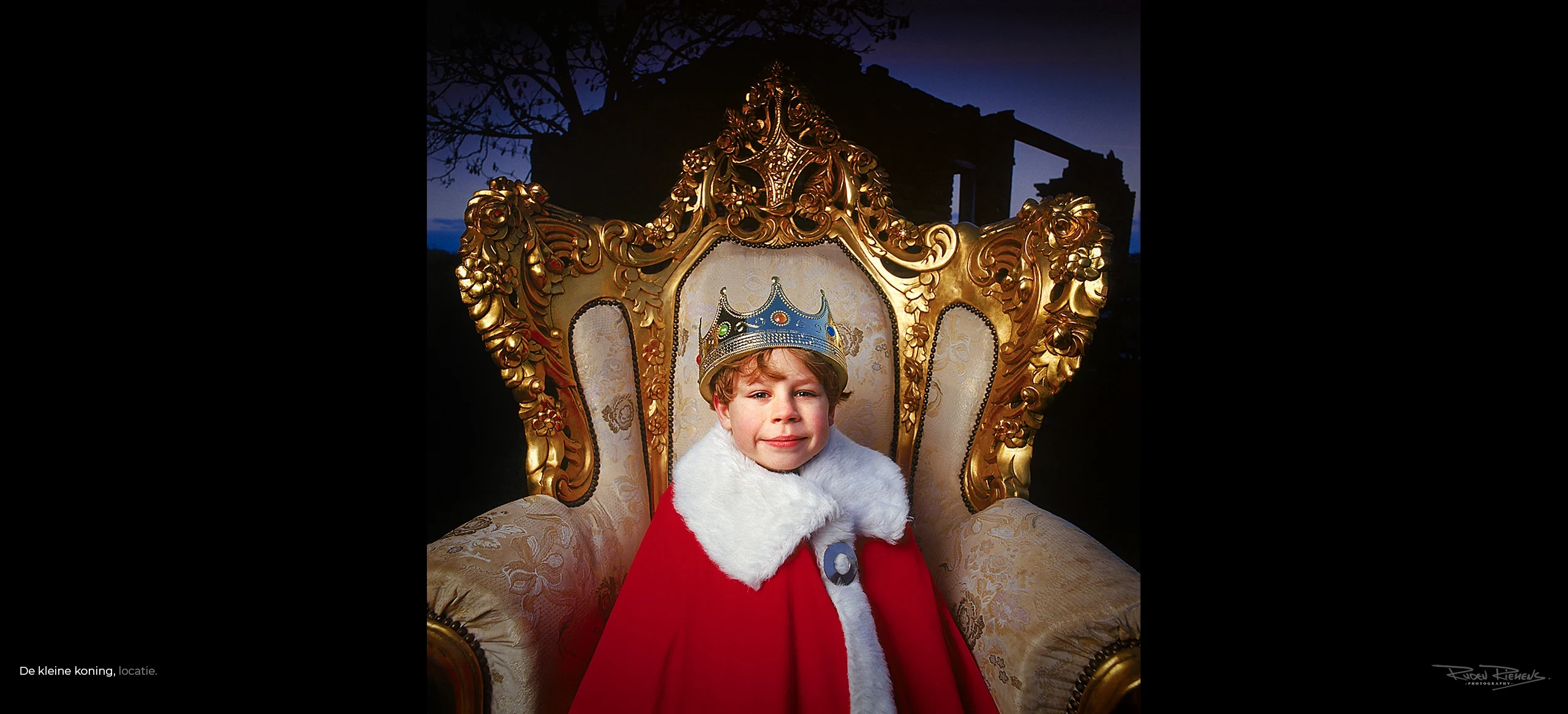 De kleine koning, portret van jongen in koningskledij op gouden zetel bij ruïne, Ruden Riemens Photography.