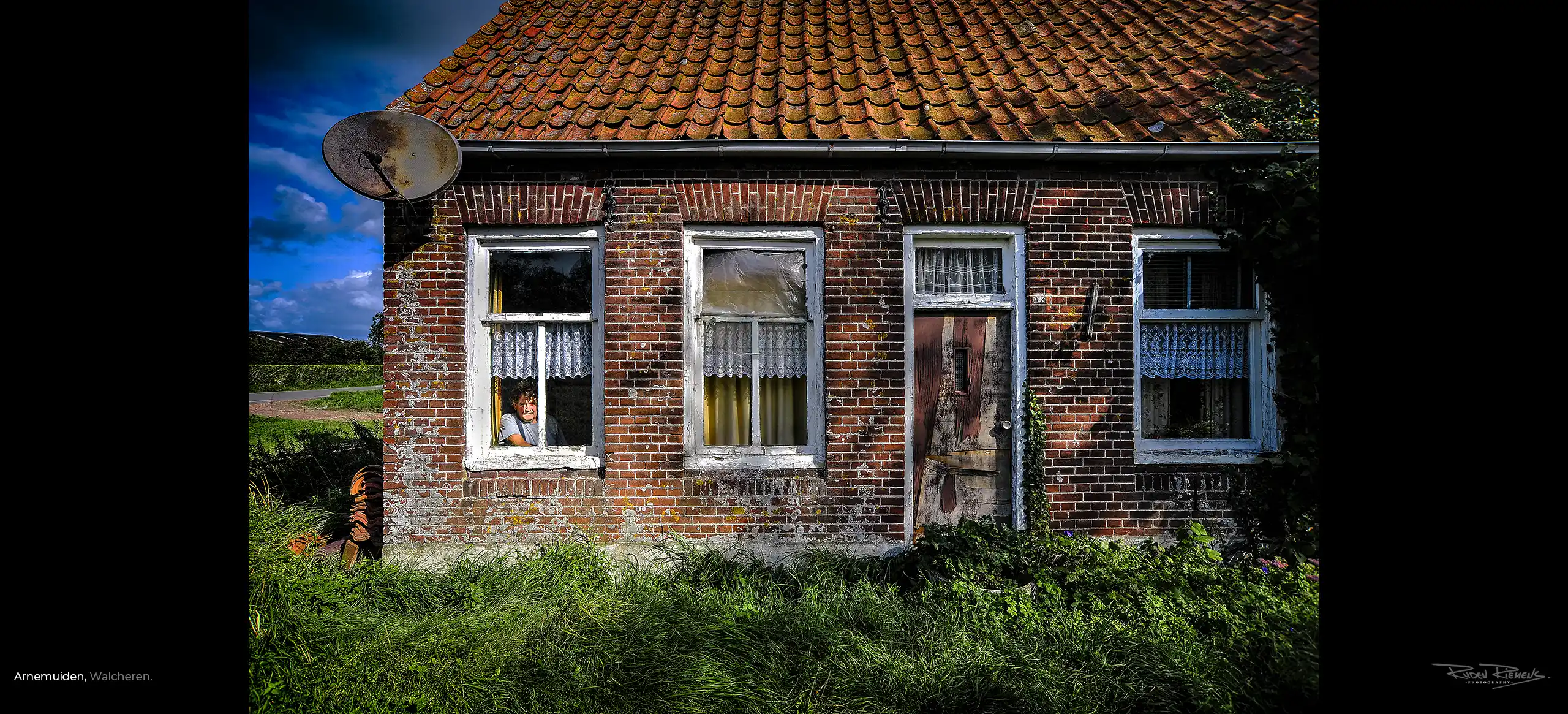 Portret van een alleenstaande boer achter het raam van zijn woning omgeving Arnemuiden Zeeland, www.rudenriemens.com.