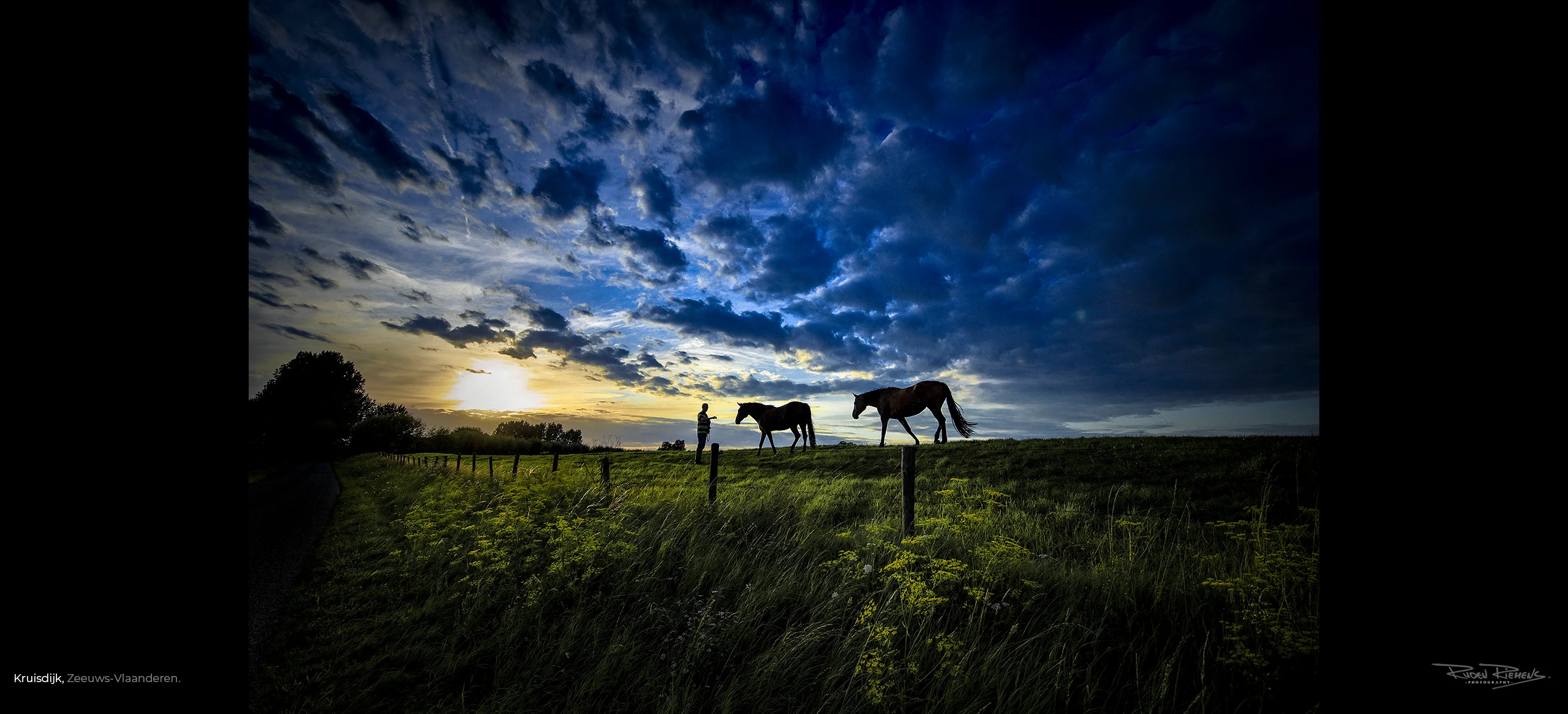 Een prachtplaat voor aan de muur, wolkenlucht met silhouet van man die paarden begroet op een grasdijk omgeving Kruisdijk Zeeuws-Vlaanderen, rudenriemens.com.