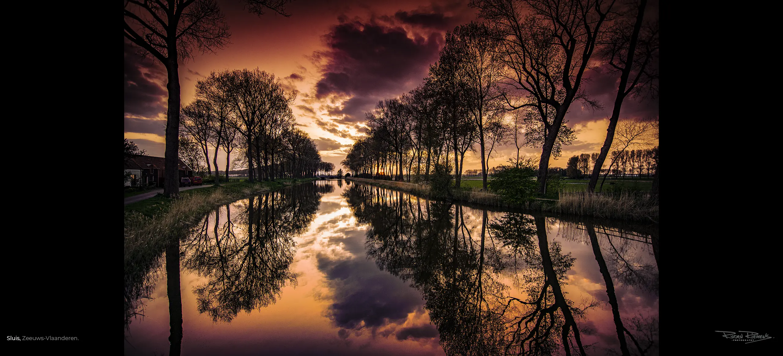 Bomenrij met avondlucht weerspiegelt in de watergang van Sluis Zeeuws-Vlaanderen, een foto uit De Zeelandkalender, Ruden Riemens Photography Zealand Color.