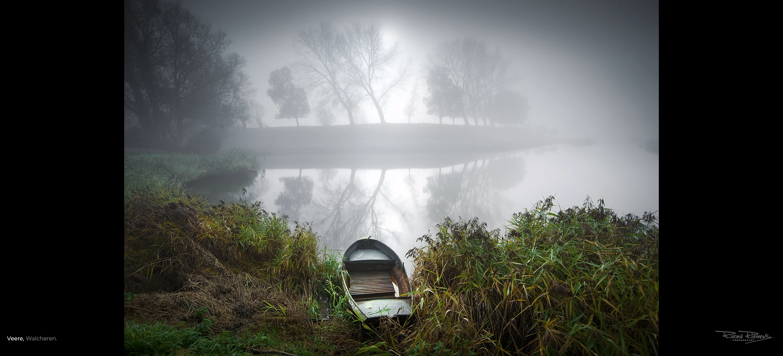 Een roeibootje tussen de rietkragen aan de oever van De Veerse Kreek, net buiten Veere, een wonderschoon stadje in Zeeland, www.rudenriemens.com.