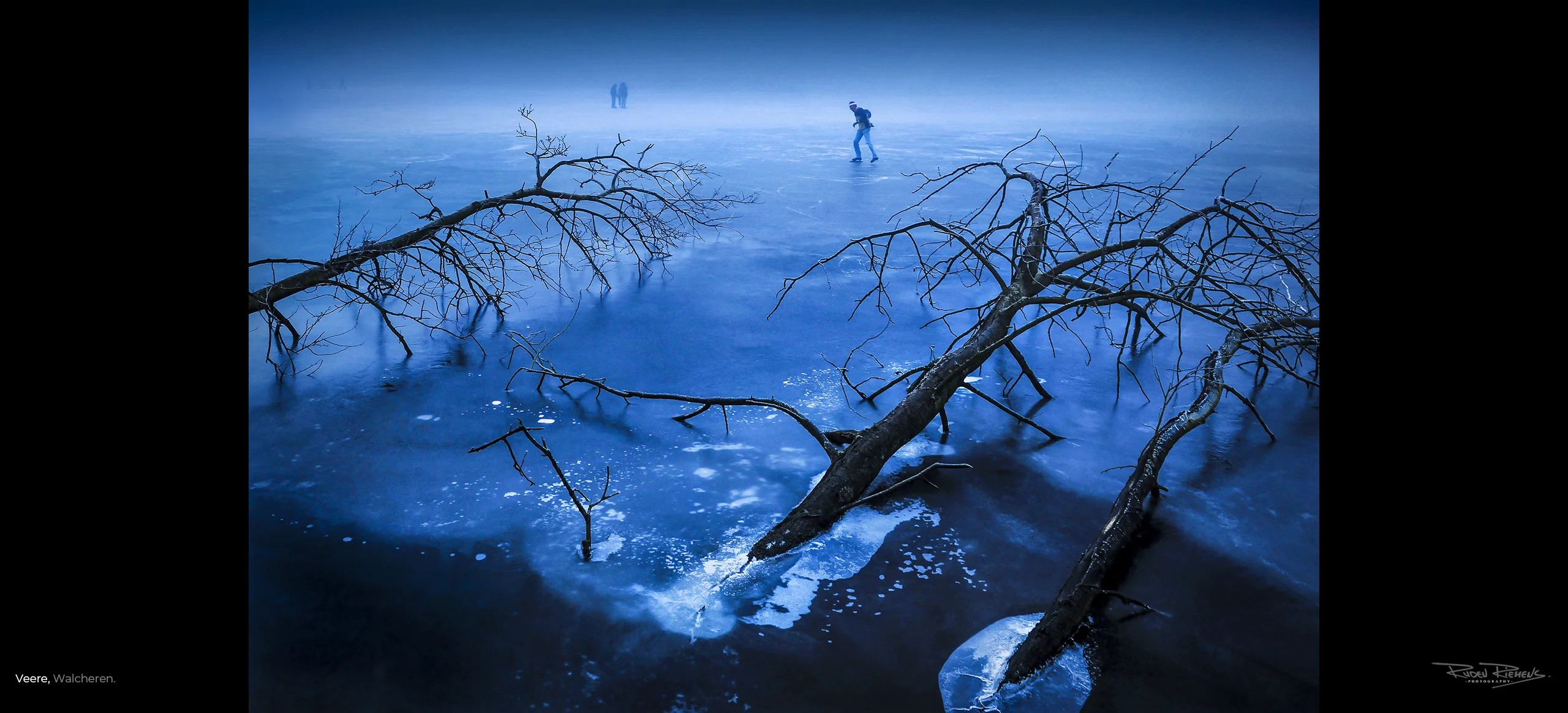 Ruden Riemens, fotograaf te Middelburg maakte deze winterfoto van de Veerse Kreek met schaatser op het ijs tussen de ingevroren bomen in Veere. Een prachtig Zeelandbeeld.