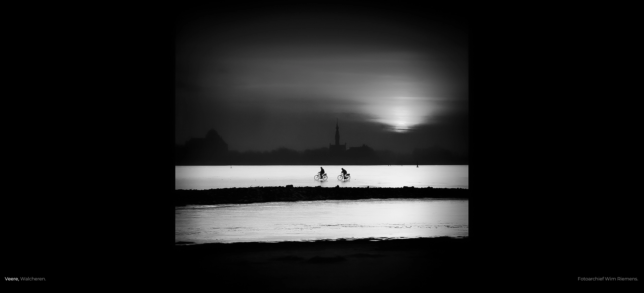 Fietsen over het bevroren Veerse Meer met het silhouet van Veere, fotoarchief Wim Riemens.