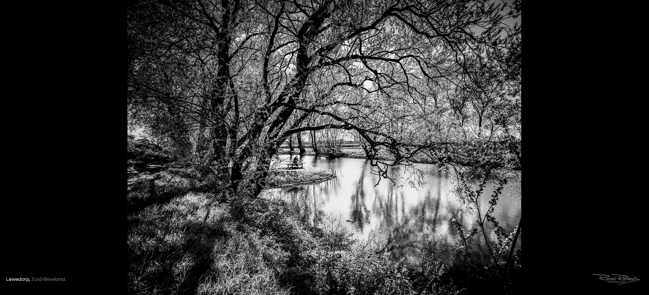 Een meisje leest een boekje in het vroege voorjaar aan de kreek in Lewedorp te Zuid-Beveland, Ruden Riemens legde het vast.