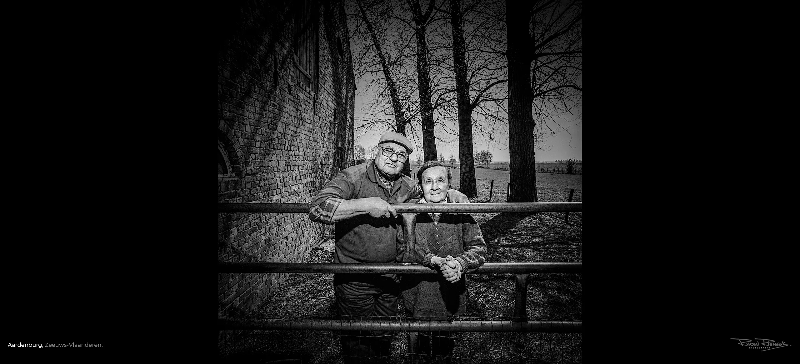 Zwart-wit portret van ouder echtpaar op hun erf door de Zeeuwse fotograaf Ruden Riemens.