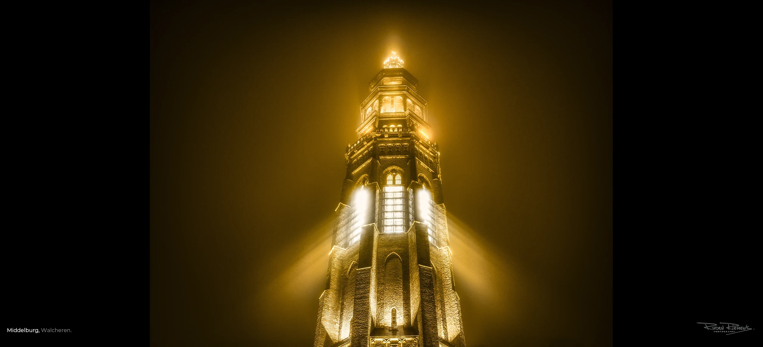 De Lange Jan te Middelburg als stralend goud in de mist, een prachtige foto voor thuis aan de muur gemaakt door fotograaf Ruden Riemens, bekend van de Zeelandkalender.