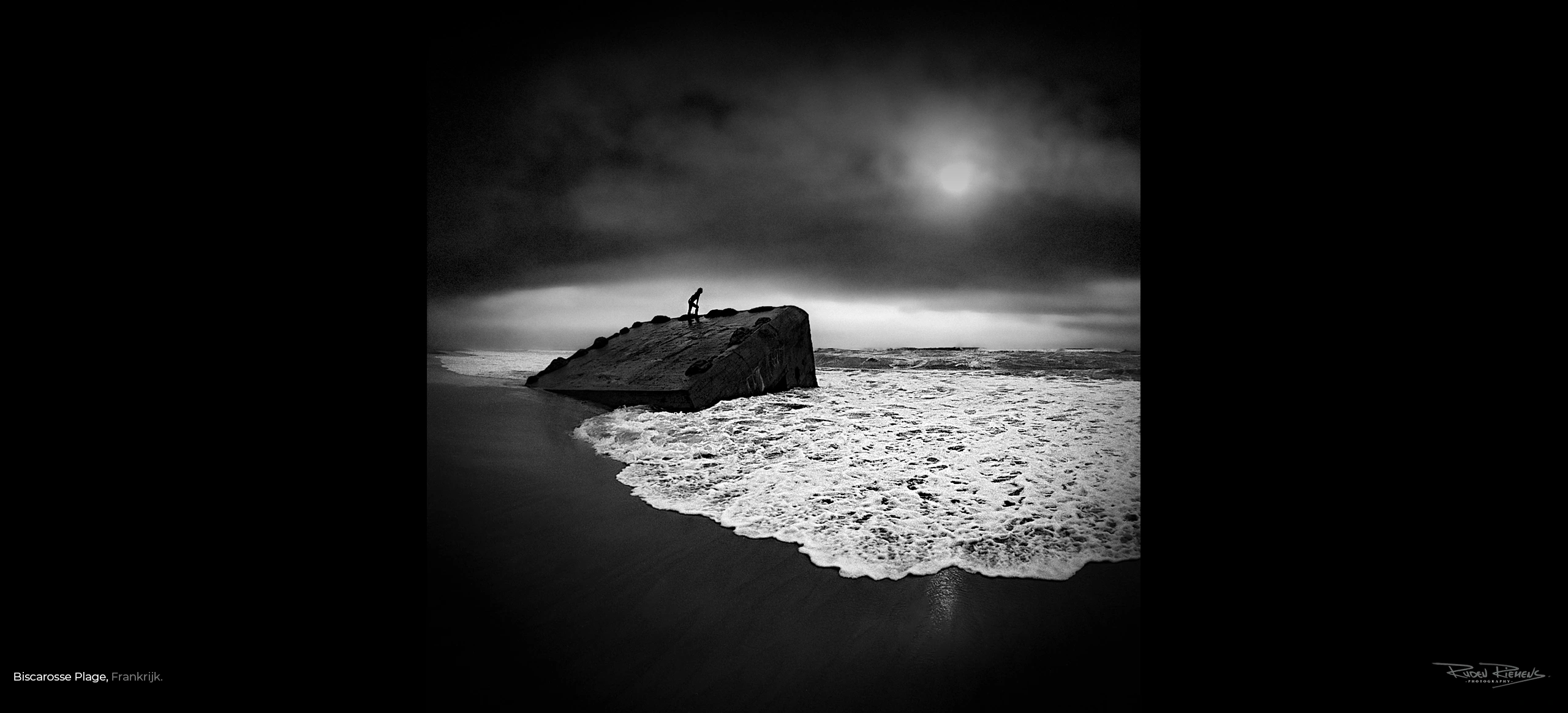 Overblijfselen van een bunker in zee uit WO2, met daarop het silhouet van iemand die uitkijkt over de golven in Biscarosse Plage, prachtig als kunst aan de muur, gefotografeerd door Ruden Riemens Fotograaf.