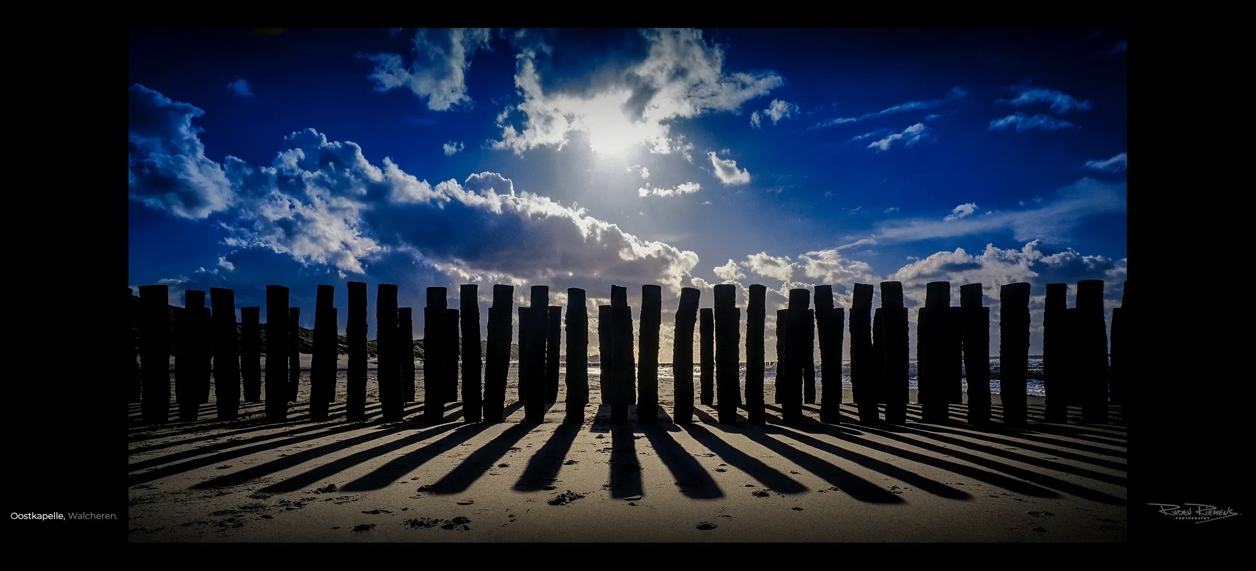 Paalhoofd op het strand te Oostkapelle op Walcheren onder wolkenlucht in tegenlicht, Ruden Riemens Fotografie Zeeland Kleur.